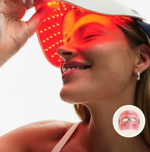 Woman wearing a red LED face mask with a small inset icon on a white background