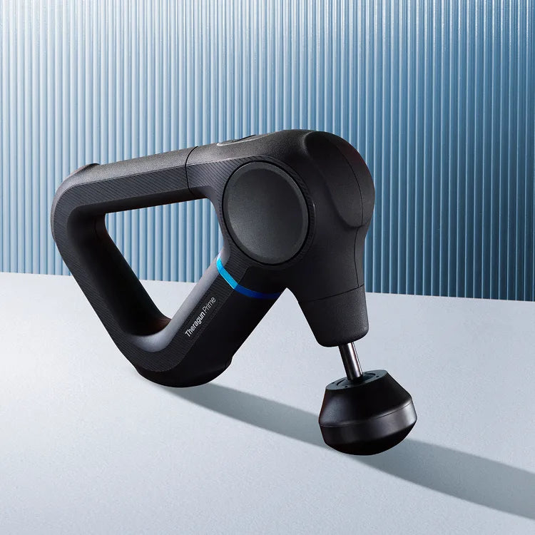Black massage gun on a light blue surface with a striped background